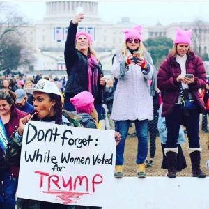 Angela holding a sign at the Women's March on Washington (photo by Kevin Banatte)