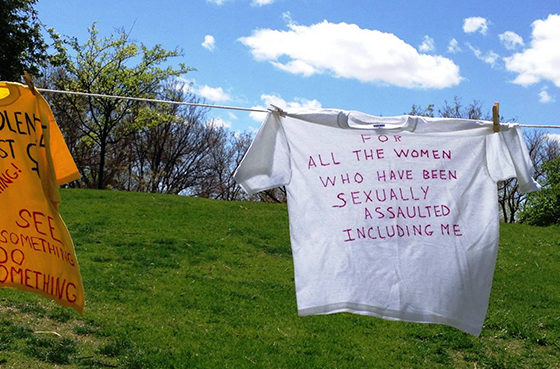 Shirt reading "For all the women who have been sexually assaulted including me" hanging on a clothesline for the "Clothesline Project"